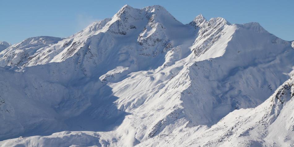 Snow-covered mountain peaks under a clear blue sky